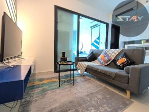 a living room with a couch and a tv at Almas Couple Stylish Urban Blue Netflix BySTAY in Iskandar Puteri