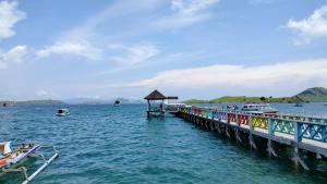 a pier in the water with boats on it at Atta komodo homestay in Komodo
