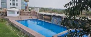 a large blue swimming pool next to a building at The Girvar Hotel, Barr in Beāwar