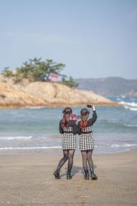 two women are standing on the beach at Free Parking and Sauna INDIGO GEO HOUSE DS2DS3 in Tajiri