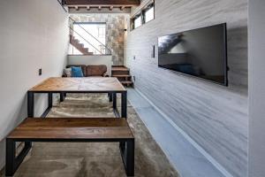 a room with a table and a tv on a wall at Free Parking and Sauna INDIGO GEO HOUSE DS2DS3 in Tajiri