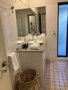 un baño con lavabo y espejo en Tali Beach House Retreat, en Oak Beach 29 fotos más