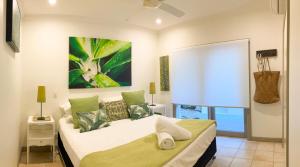 Un dormitorio con una cama y un cuadro en la pared. en Tali Beach House Retreat, en Oak Beach