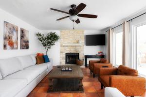 a living room with a white couch and a ceiling fan at Pool HotTub FirePit BBQ Billiard PS4 Golf in Pflugerville