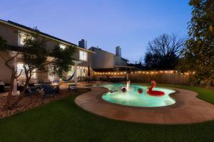a swimming pool with a flamingo in the middle of a yard at Pool HotTub FirePit BBQ Billiard PS4 Golf in Pflugerville