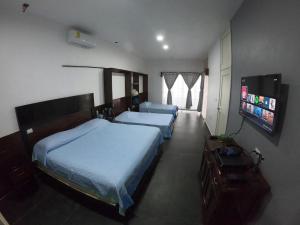 Un dormitorio con dos camas y un televisor de pantalla plana. en Casa Playa Tortugas, en Vega de Alatorre