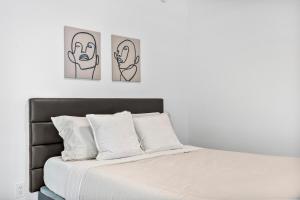 a bedroom with three pictures of faces on the wall at Luxury Studio,Downtown Miami, in Miami