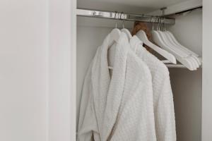 a closet with white towels hanging on a rack at Orewa Beachcomber in Orewa