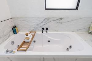 a large white bath tub in a bathroom at Orewa Beachcomber in Orewa