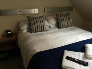 a bed with pillows and a night stand at York Aparthotel in York