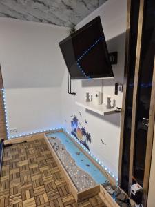 a tv hanging above a swimming pool in a room at Little Paradise Spa Appartement in Gummersbach