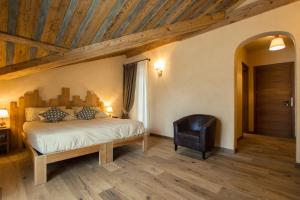 a bedroom with a bed and a chair at Hotel Les Montagnards in Morgex