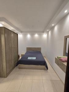 um quarto com uma cama com um cobertor azul em Florenza Khamsin em Hurghada