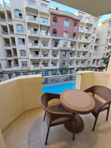 uma varanda com uma mesa e cadeiras e um edifício em Florenza Khamsin em Hurghada