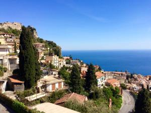 a town on a hill with the ocean in the background at Villa Quisisana Taormina in Taormina