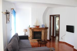 a living room with a couch and a fireplace at Baleal Holiday Apartment in Baleal