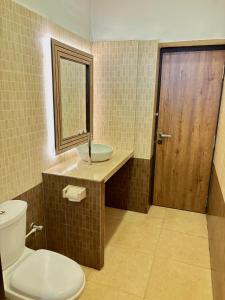 a bathroom with a toilet and a sink and a mirror at Zeenath Taj Gardens in Yelagiri +92 photos