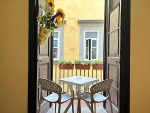 a table and chairs on a balcony with a window at SanBiagio, 25 Guesthouse in Naples