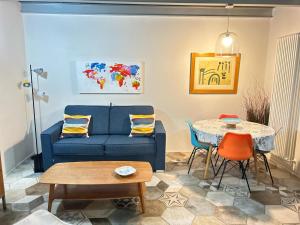 a living room with a blue couch and a table at SanBiagio, 25 Guesthouse in Naples