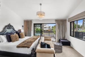 a bedroom with a large bed and a living room at Orewa Beachcomber in Orewa