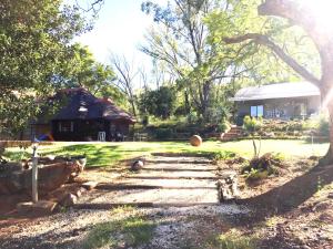een tuin met een stenen pad naar een huis bij Hadida Guesthouse in Swartruggens