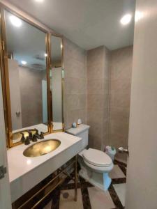 ジョムティエンビーチにあるEspanna condo jomtien By SuneeyaA9の洗面台、トイレ、鏡のあるバスルーム
