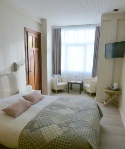 a bedroom with a large bed and a living room at Hotel Georges in Wenduine