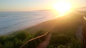 a view of the beach at sunset at Dolphin Dunes Guesthouse in Wilderness +157 photos