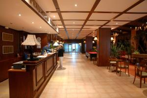 a lobby of a restaurant with a woman standing at a counter at Hotel Prespa in Pamporovo +42 photos
