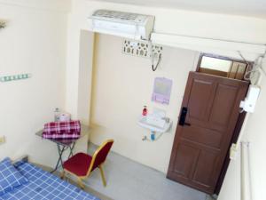 a room with a door and a chair and a sink at Jade Crown in Yangon