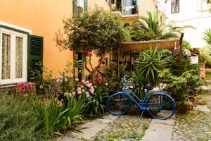 Una bicicleta azul estacionada en un jardín con flores en Albergo Costa, en Imperia