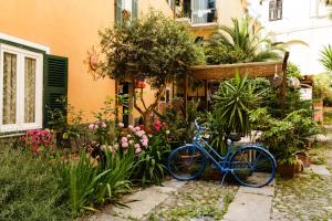 Un vélo bleu garé dans un jardin fleuri dans l'établissement Albergo Costa, à Imperia
