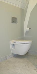 a white toilet in a room with a wall at House of Cocagne in Kockengen