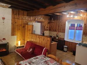 a living room with a red couch and a kitchen at Au repos près du lac in Vertamboz