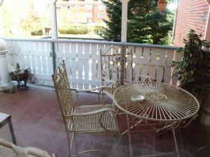 een patio met een tafel en stoelen op een veranda bij Ferienwohnung Emma in Leer