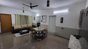 a living room with a couch and a table at Ashirwad Residency Inside Manyata Tech Park in Bangalore