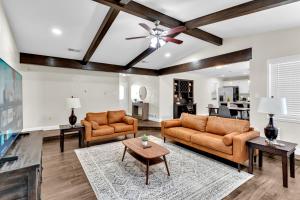 a living room with two couches and a table at Casa Parkside in Grand Prairie