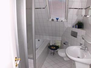 een badkamer met een bad, een toilet en een wastafel bij Ferienwohnung Emma in Leer