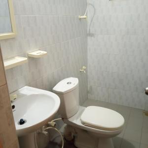 een witte badkamer met een toilet en een wastafel bij 1907 Park View in Anuradhapura