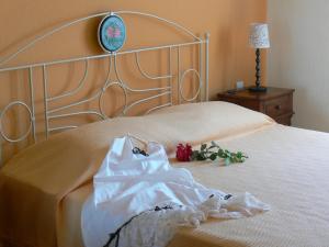 a white dress on a bed with a lamp and a clock at Alkyon Villas in Syvota