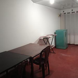 een kamer met een tafel en stoelen en een groene kachel bij 1907 Park View in Anuradhapura