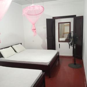 een kamer met twee bedden en een roze ballon bij 1907 Park View in Anuradhapura +5 foto's