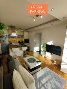 a living room with a couch and a kitchen at Ana Apartment in Novi Sad