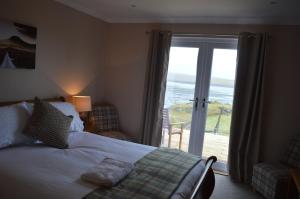 a bedroom with a bed and a view of the ocean at The Tide in Dunvegan