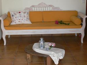 a yellow couch with a table and a bottle on it at Alkyon Villas in Syvota