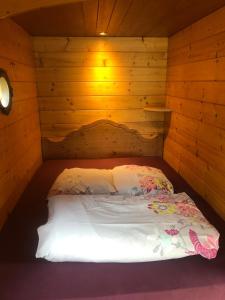a bedroom with a bed in a wooden cabin at La Roulotte d'Alcas in Saint-Jean-et-Saint-Paul