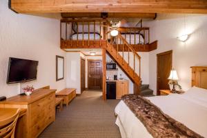 a hotel room with a bed and a staircase at Kandahar Lodge at Whitefish Mountain Resort in Whitefish