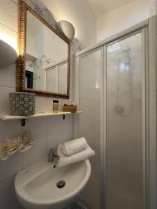 a bathroom with a sink and a shower with a mirror at Residenza San Martino in Scarperia