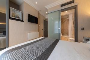 a bedroom with a bed and a tv on the wall at Habitus Hotel Europa in Pamplona
