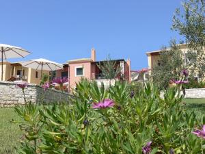 a house with a garden with flowers in the foreground at Alkyon Villas in Syvota